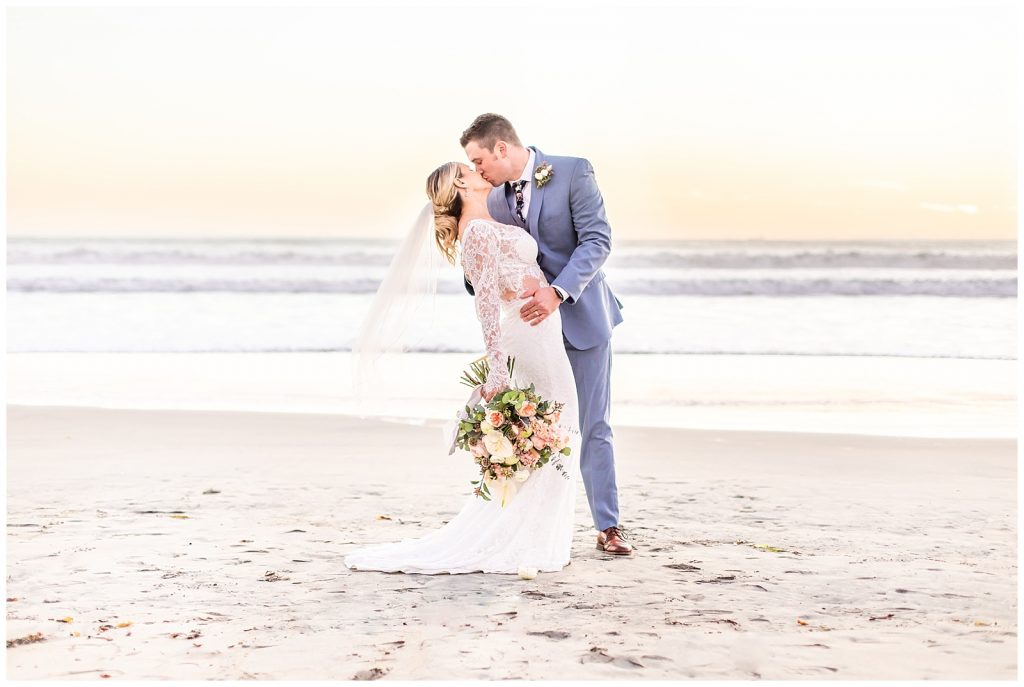 Couple on the beach kissing on their wedding day