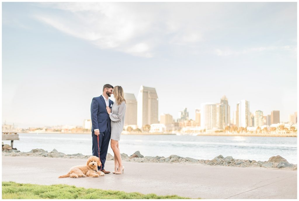 couple with a dog with San Diego skyline in the background