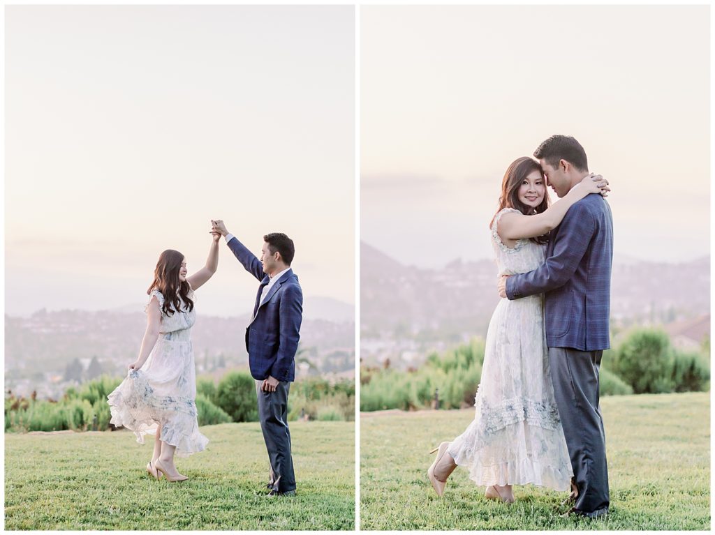 Couple on a hilltop facing each other and dancing on their engagement session in La Jolla, CA