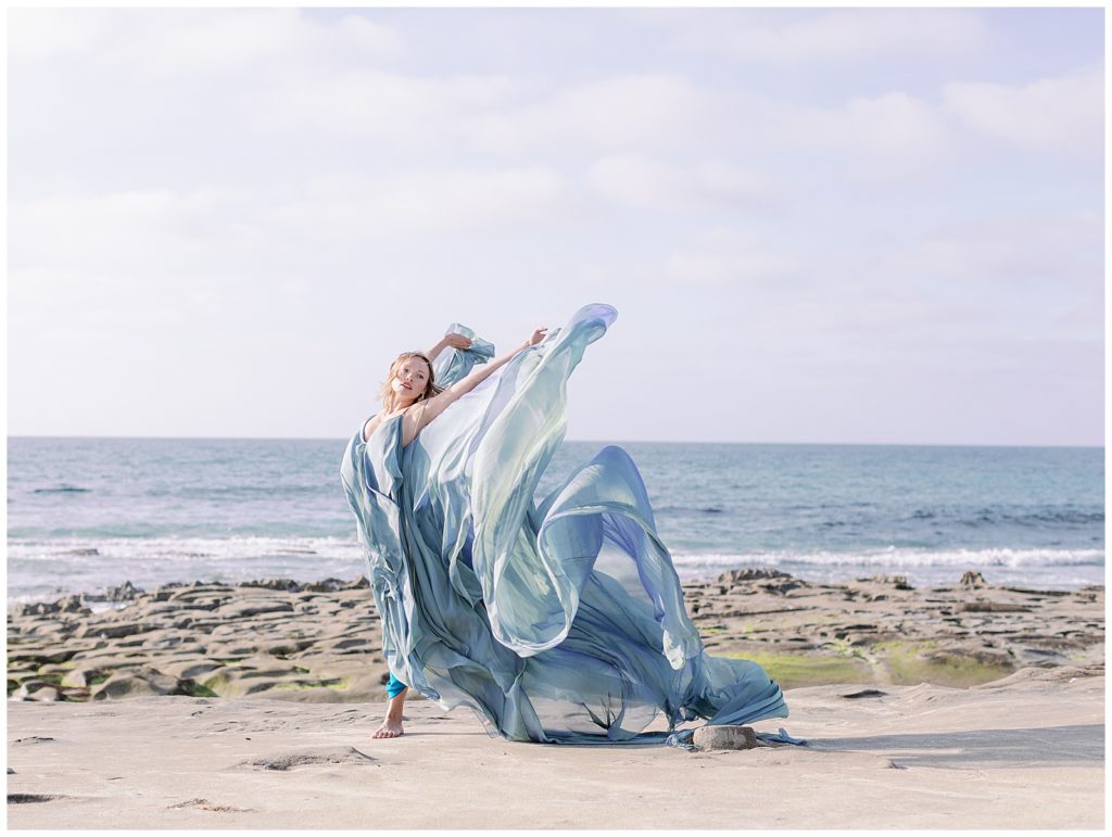 girl dancing with flowy dress on the beach in La Jolla