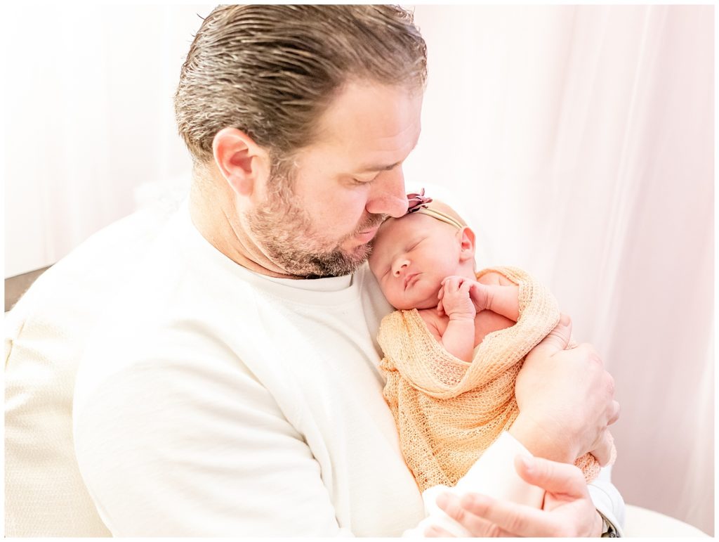 lifestyle photo of newborn baby girl being held by her dad