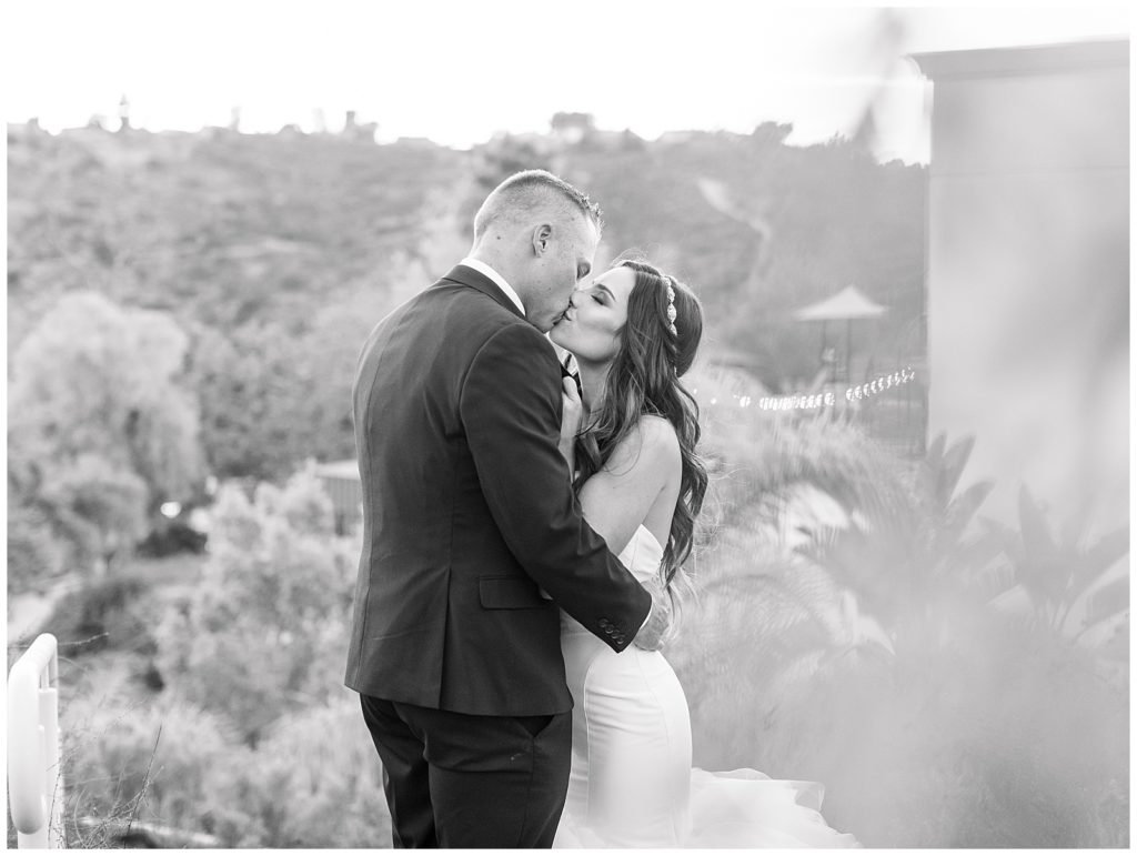 black and white photo of bride and groom kissing