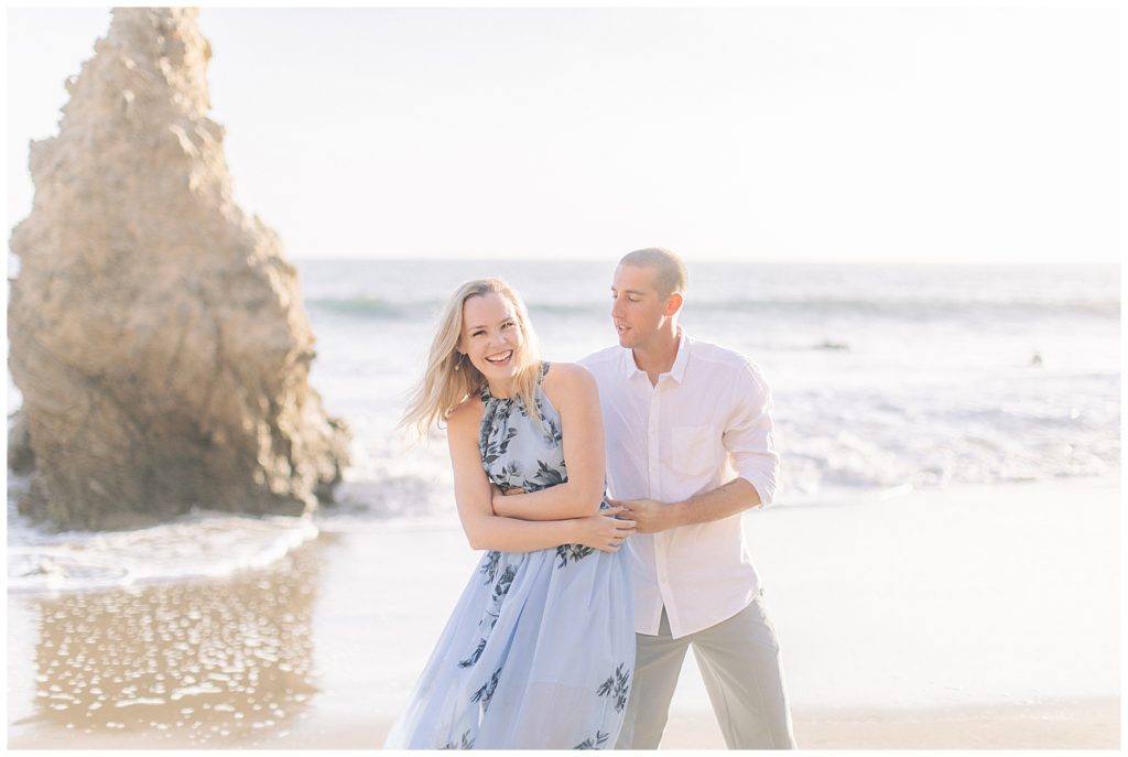couple walking holding hands at el matador beach for their engagement session