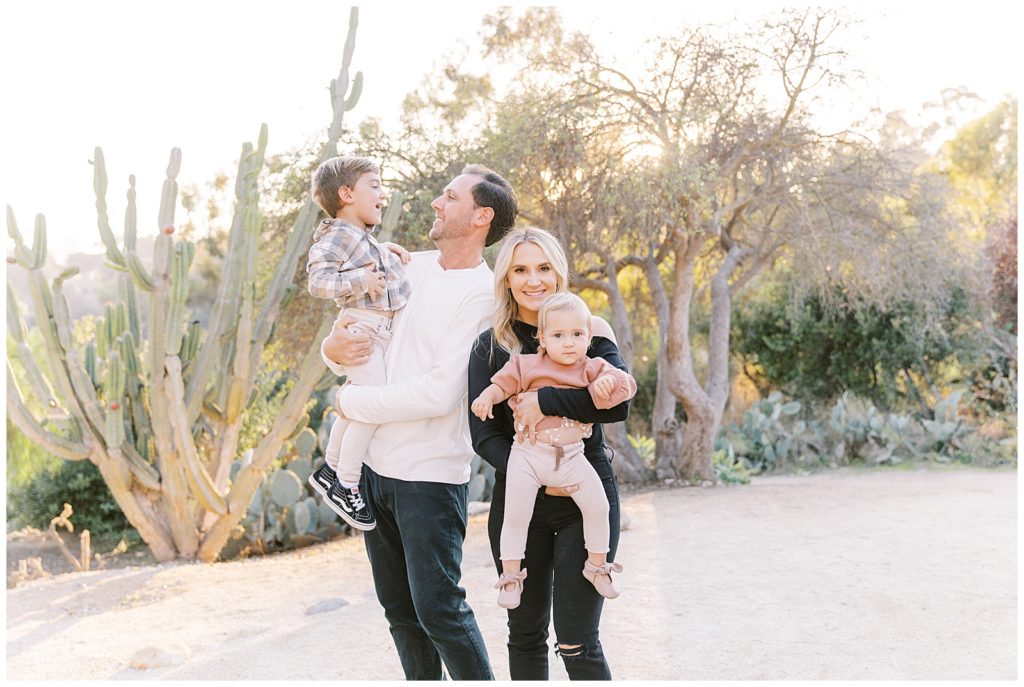 family of mom and dad and toddler boy and toddler girl together in cactus garden