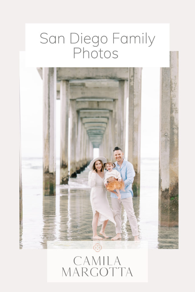 mom and dad with toddler girl under the La Jolla scripps pier