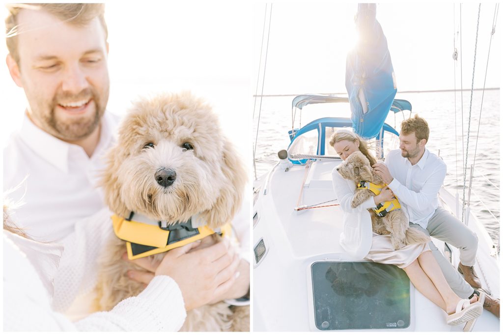 couple on a sailboat holding their dog, with the view of the ocean in the back