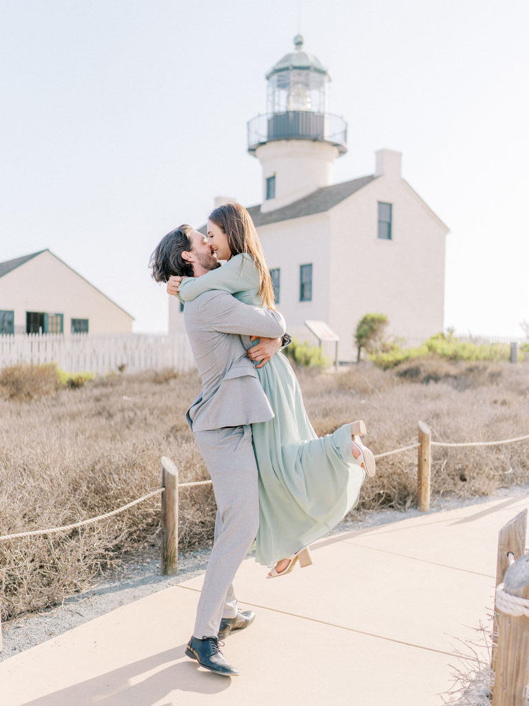 couple embracing each other and spinning in front of the Old Point Loma Lighthouse 