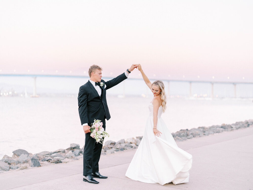 bride and groom dancing with the San Diego bay and Coronado bridge as a backdrop 