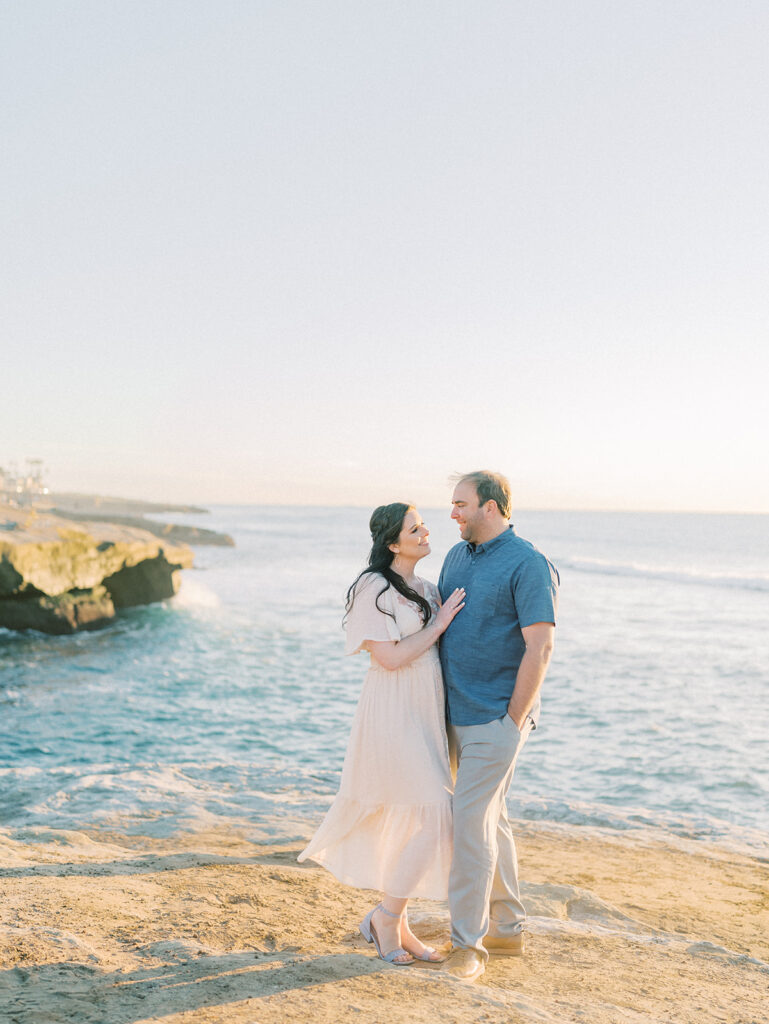 Cliffside overlooking the ocean in sunset cliffs with couple facing each other during sunset