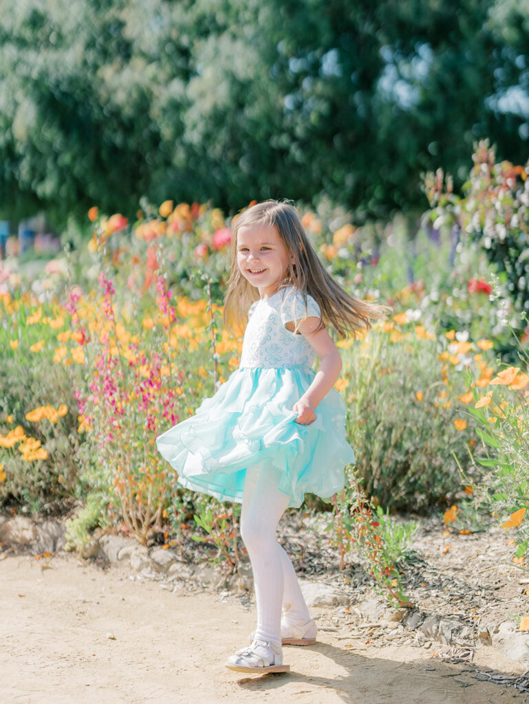 little girl twirling through garden at mission San Juan Capistrano 