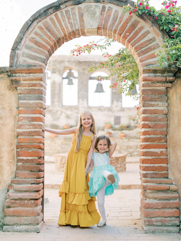 little girl in archway at the mission san Juan Capistrano family session