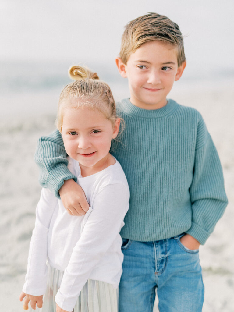 Kids smiling lovingly at the beach