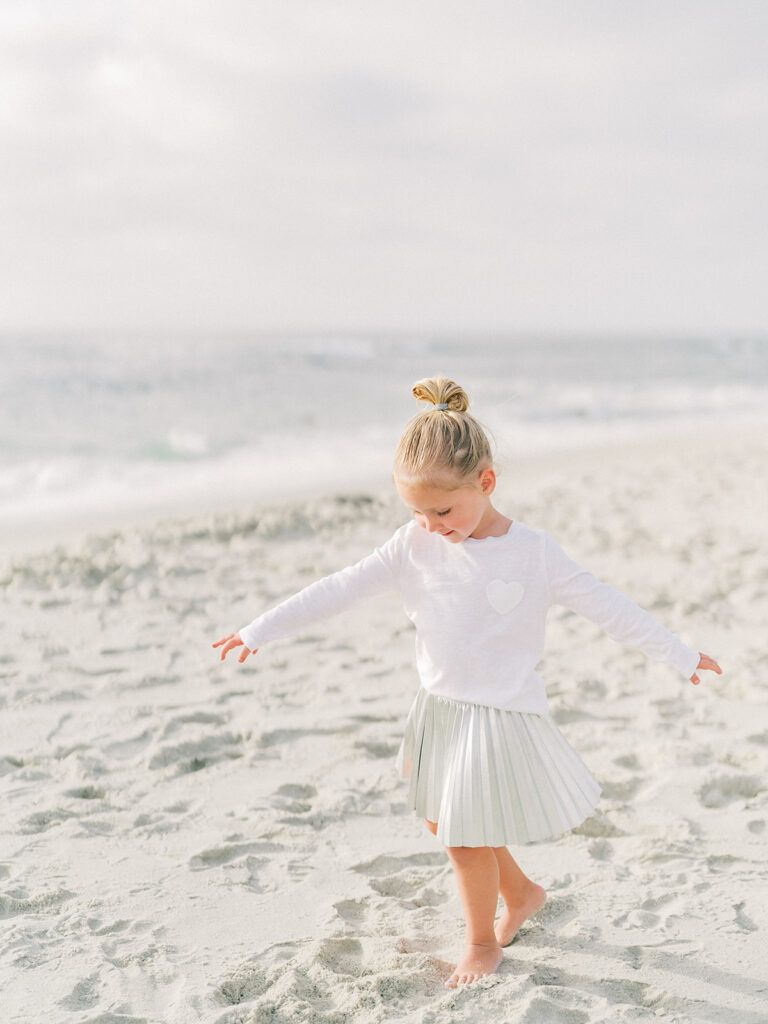 Little girl walking on the sand