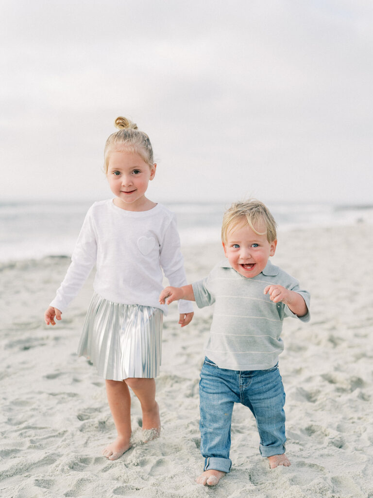 Little girl with her little brother walking along La Jolla shores