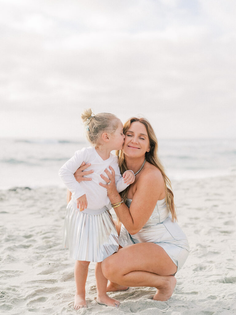 Little girl kissing her mother during La Jolla family photography session