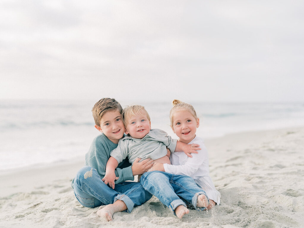 Kids sitting on the sand of La Jolla shores