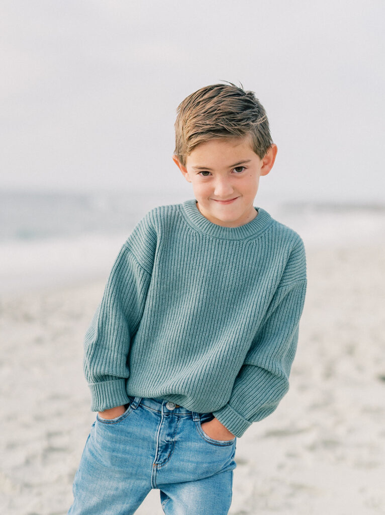 Little boy posing like a model on the beach