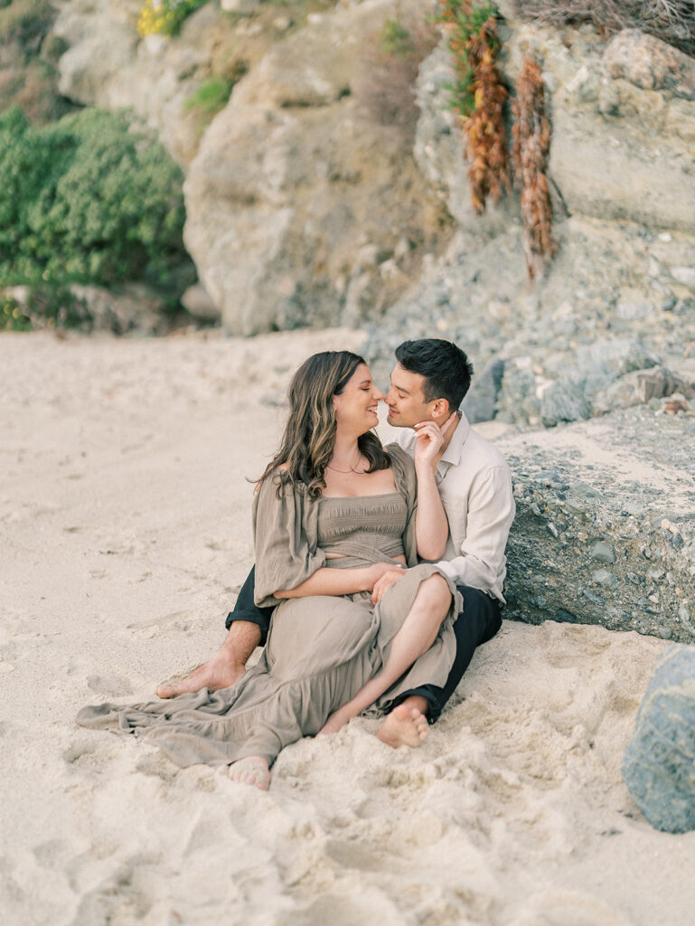 A couple sitting on the sand at Laguna Beach