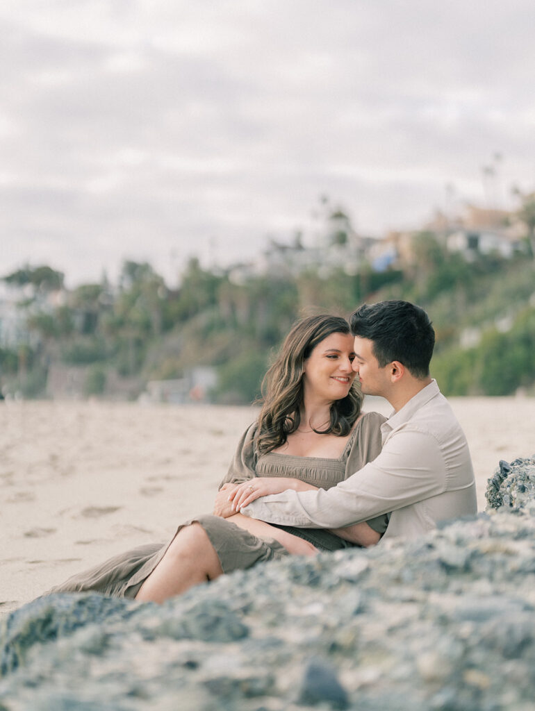 A couple sitting on the sand at Laguna Beach