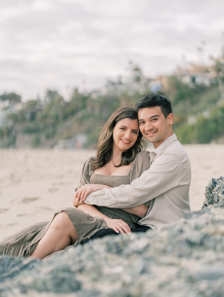 A couple sitting on the sand at Laguna Beach