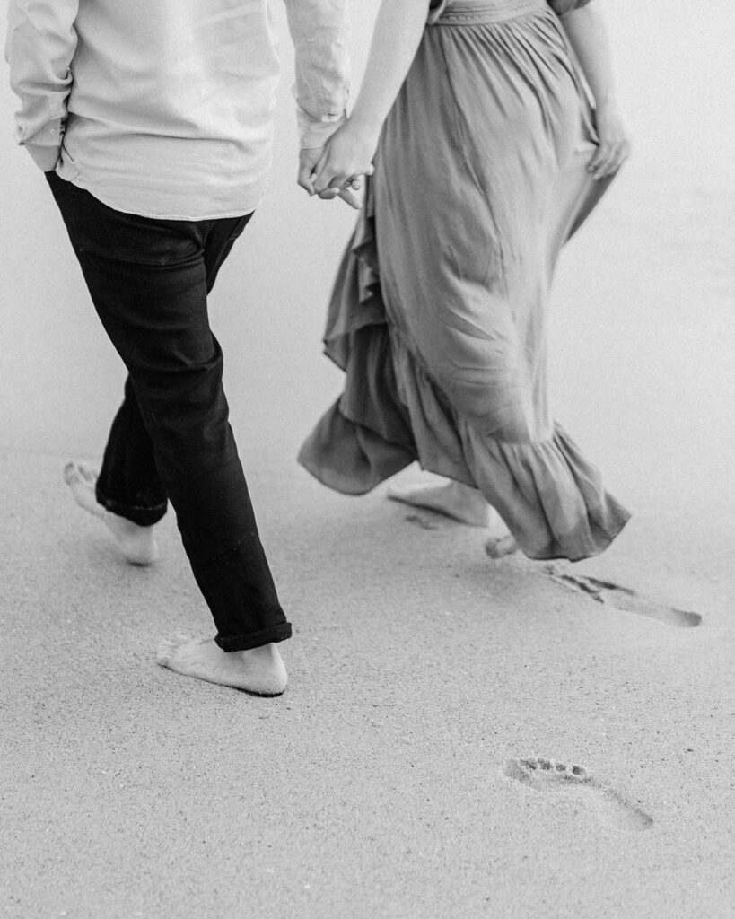 Footprints in the sand left by a couple during their engagement session at Laguna Beach