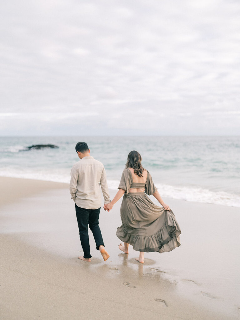 A couple walking at Laguna Beach for their engagement shoot