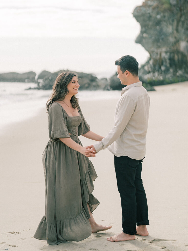 A couple staring with each other while holding hands