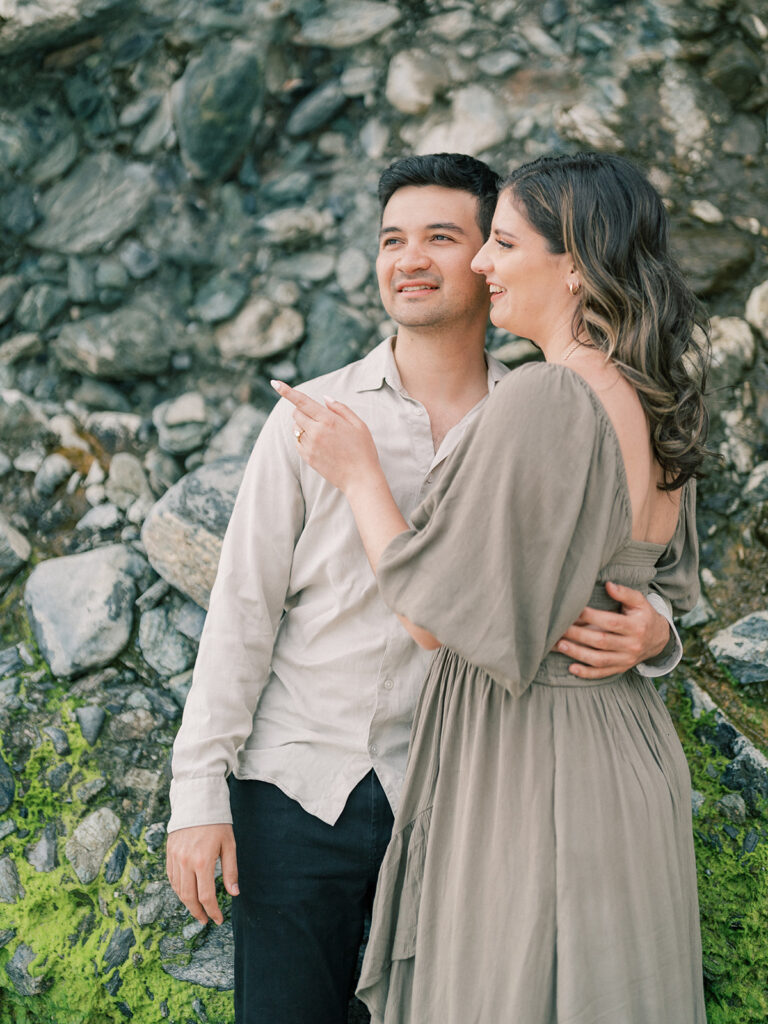 A couple next to each other while a  woman pointing on something far