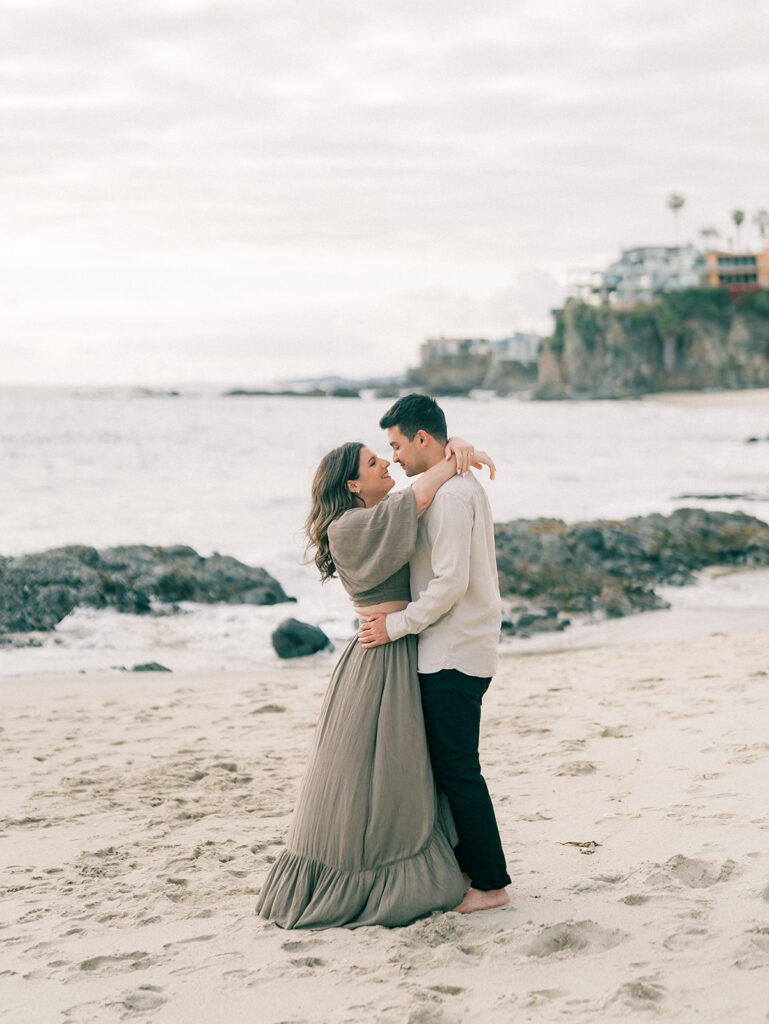 A couple during engagement shoot with Laguna Beach as their backdrop