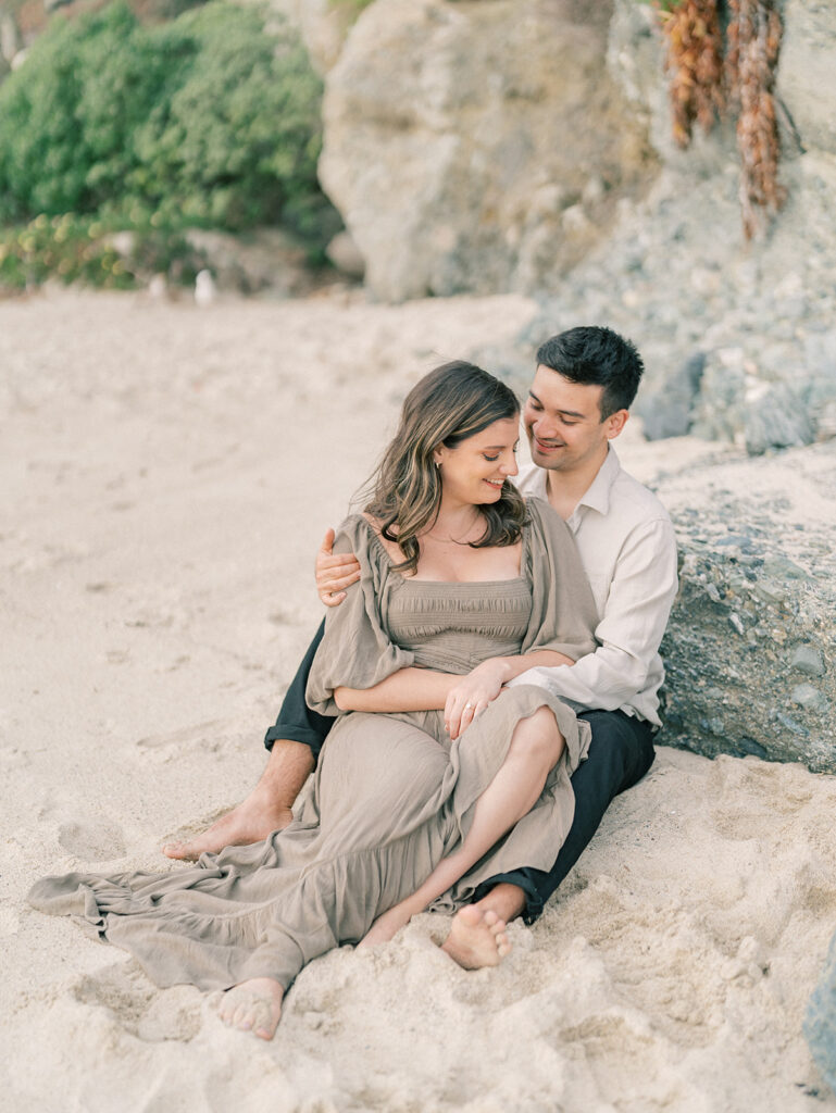 A couple sitting on the sand at Laguna Beach