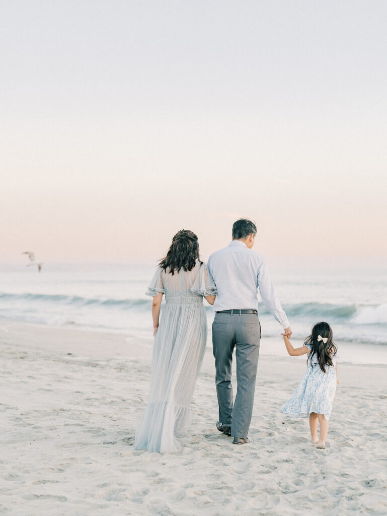 Back photo of a family walking at Coronado Beach captured by San Diego maternity photographer