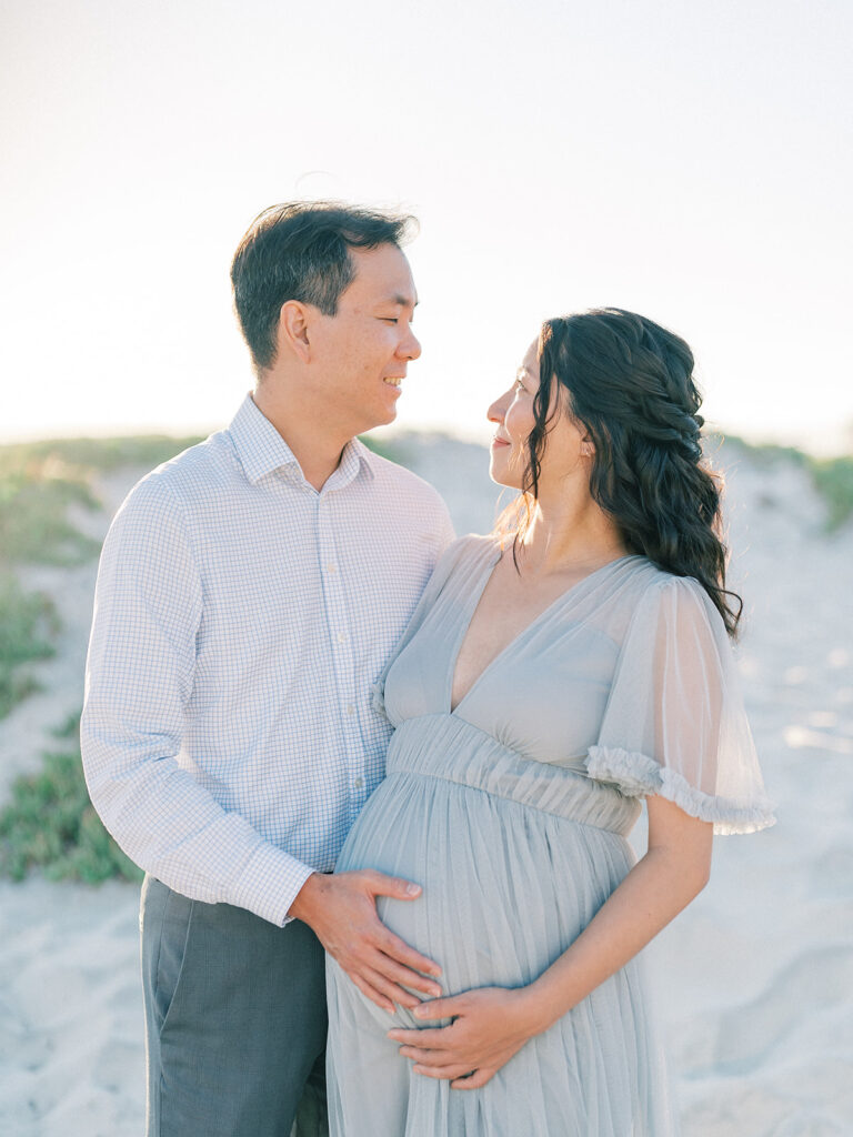 Her husband holding her pregnant belly captured by San Diego maternity photographer