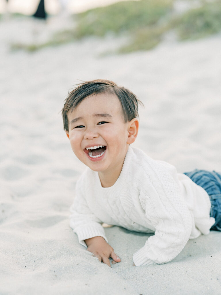 a toddler wearing white sweater while smiling