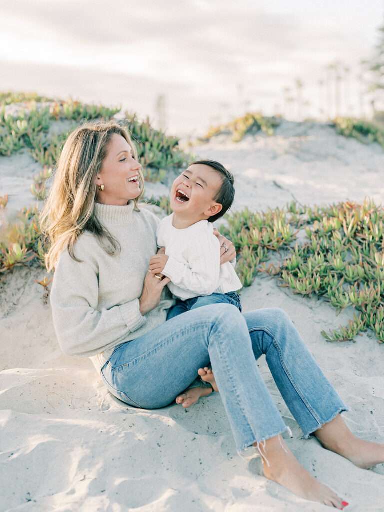 a mother with her son laughing at coronado beach in san diego