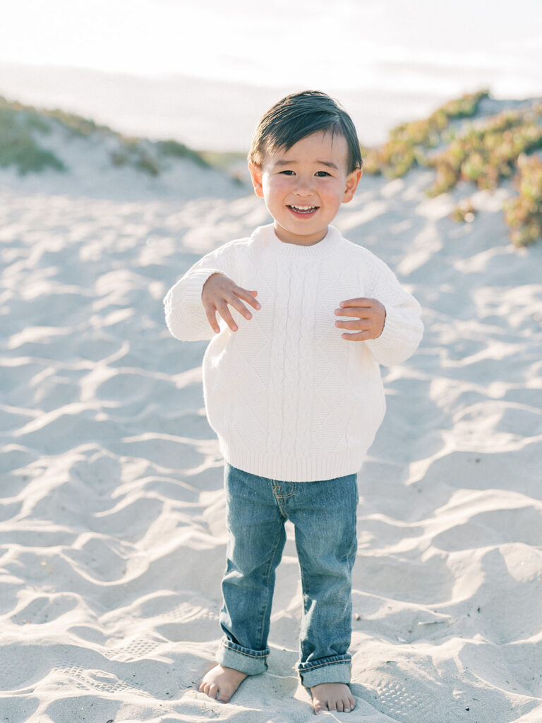 a toddler wearing white sweater while smiling