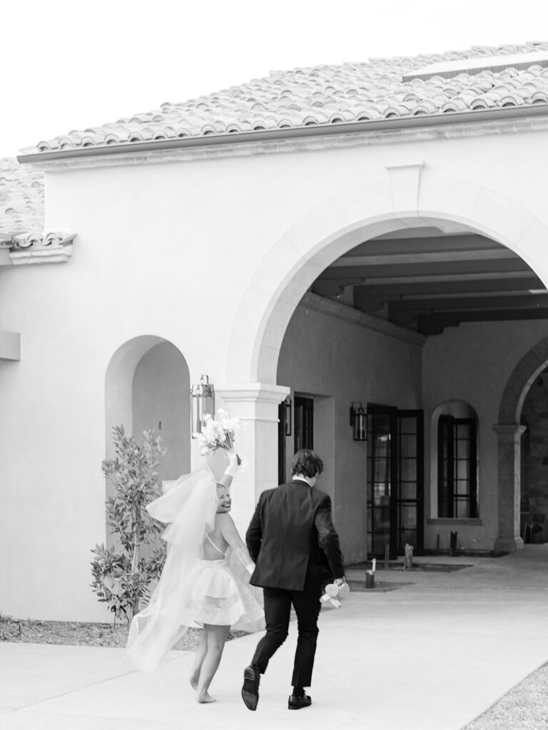 black and white photo of a couple runing at monserate winery during styled dhoot wedding 