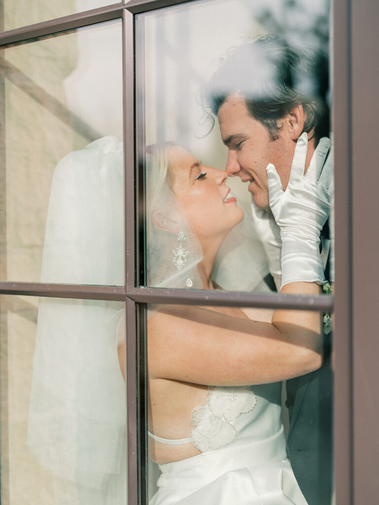 A romantic shot of a couple framed by a window