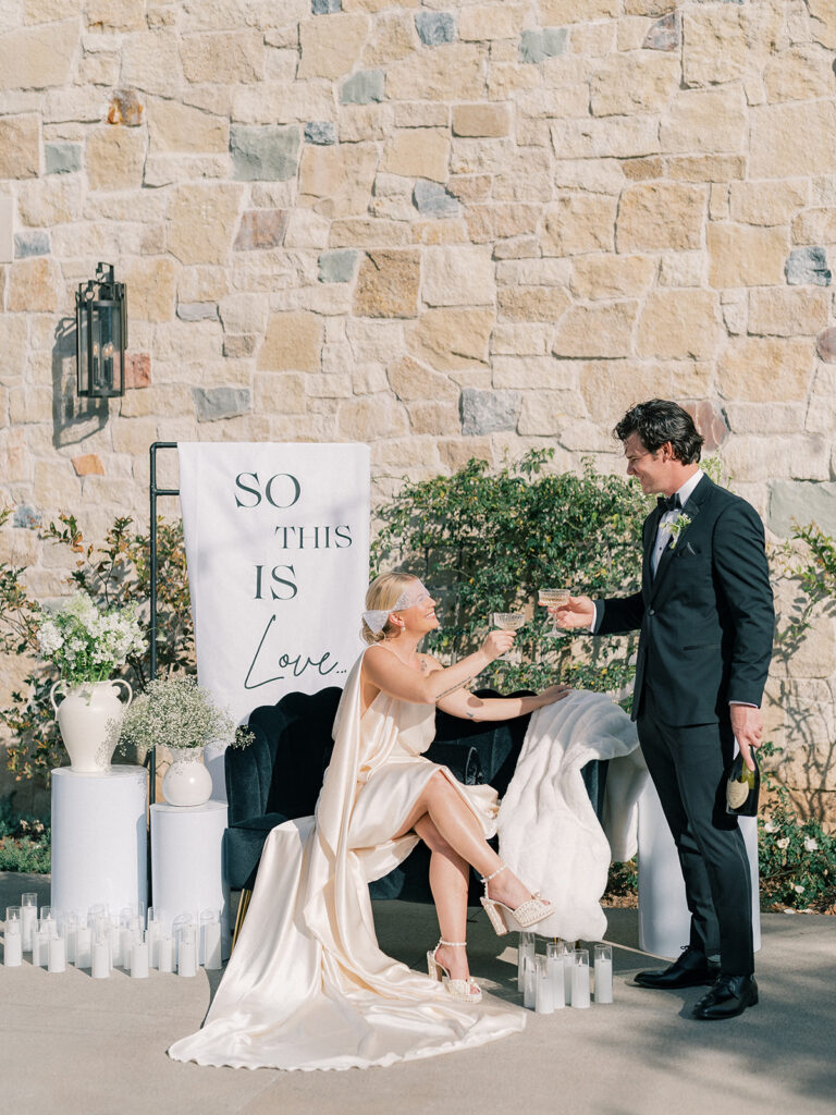 a bride and groom raising their glasses for a toast