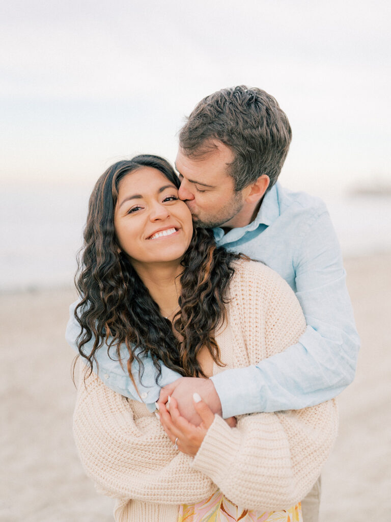 a close up photo of a man kissing his woman on her cheeks