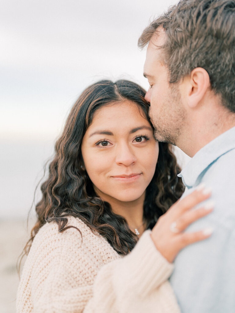 a man kissing her woman's forehead 