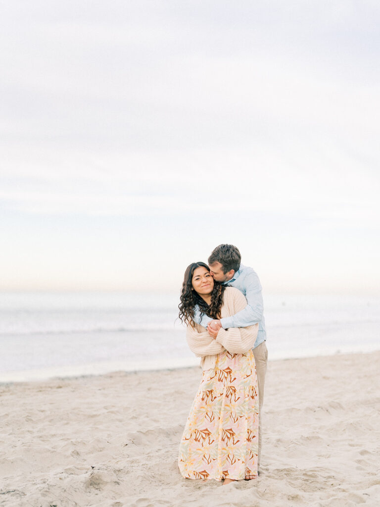 a man doing a back hug on her woman at pacific beach